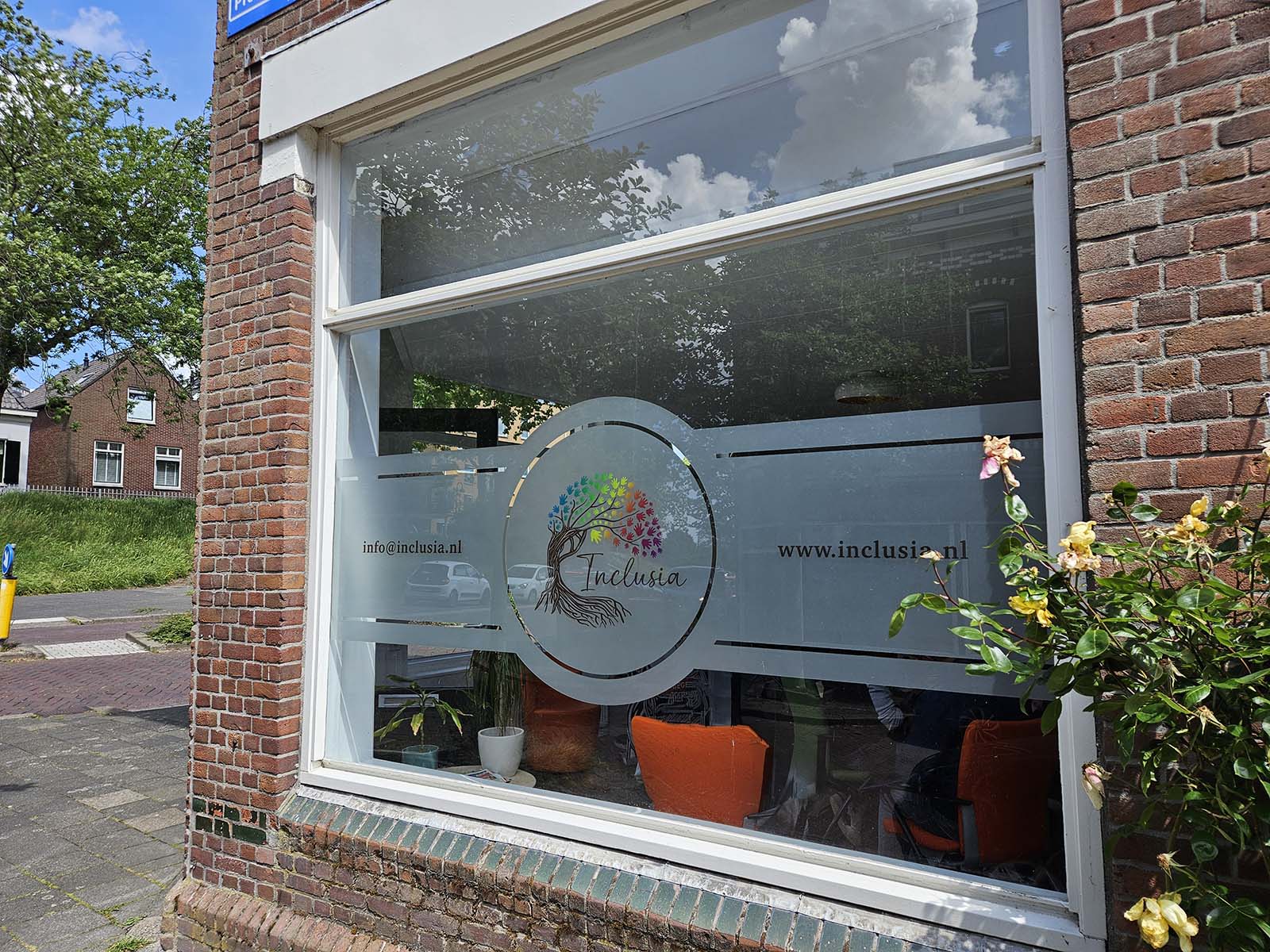 Op maat bedrukte en uitgesneden matglasfolie met kleurrijk logo biedt niet alleen privacy, maar versterkt ook de zichtbaarheid en identiteit van Inclusia aan de straatzijde.