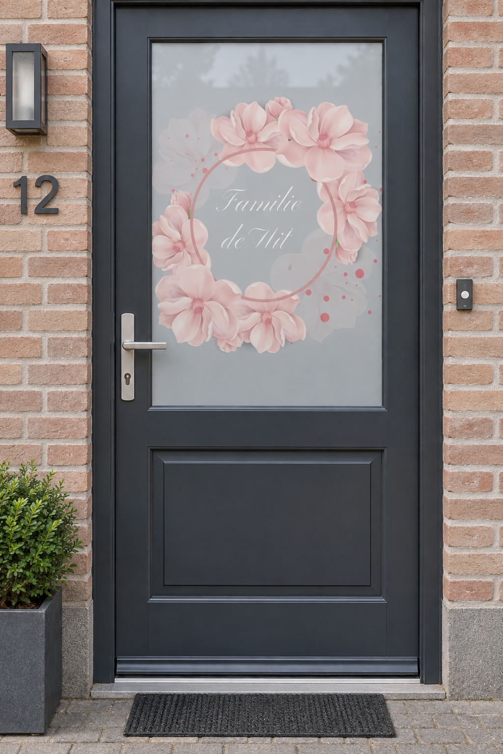 Voordeur met bedrukte matglasfolie bloemen en familienaam, frontaal aanzicht.