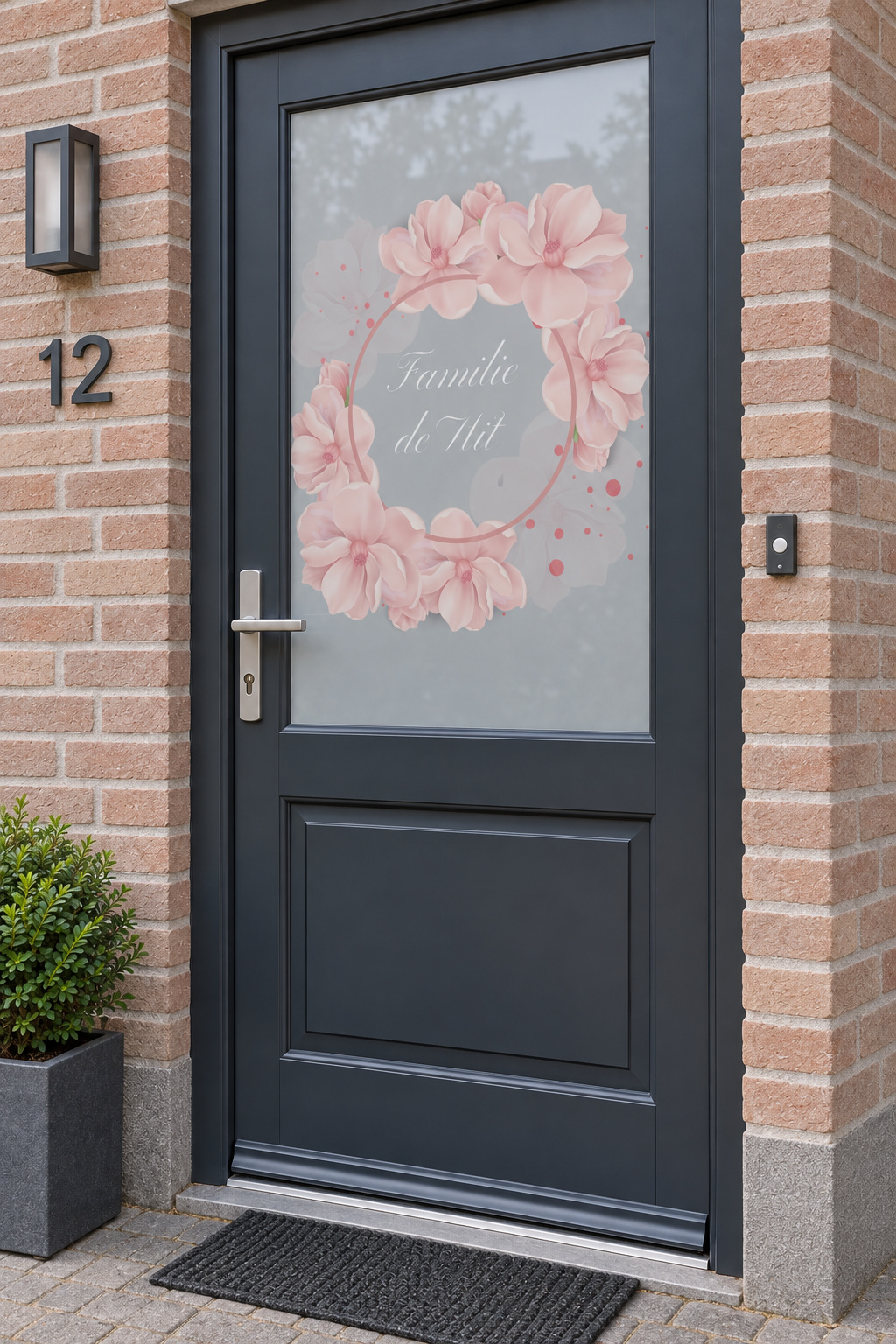 Voordeur met bedrukte matglasfolie bloemen en familienaam, licht schuin aanzicht.