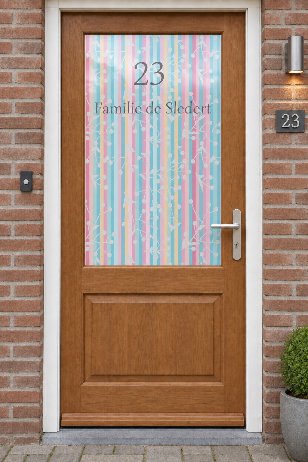 Voordeur met bedrukte matglasfolie gekleurde strepen, naam en huisnr, frontaal aanzicht.