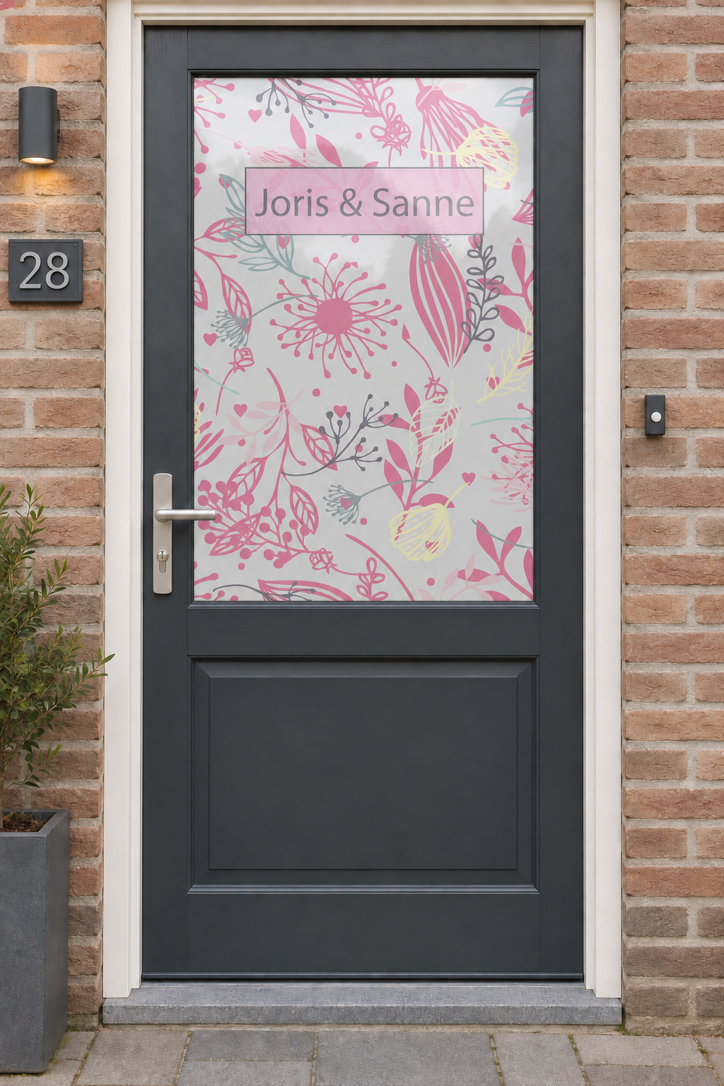 Voordeur met bedrukte matglasfolie gekleurde takjes (roze) met naam, frontaal aanzicht.