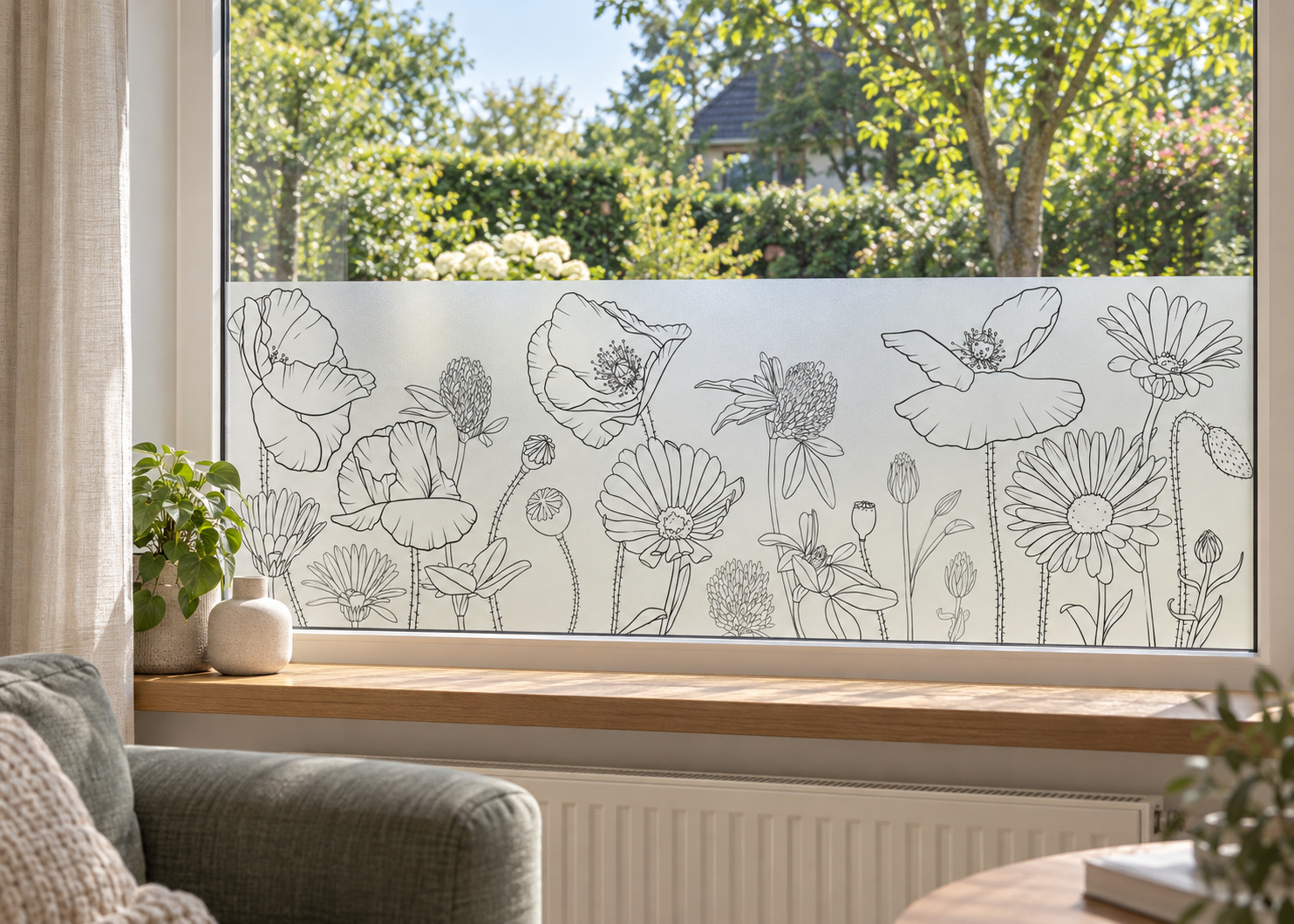 Matglasfolie met fijn getekende bloemen, horizontaal aangebracht boven de vensterbank in een woonkamerraam; ontwerp RFH010B.