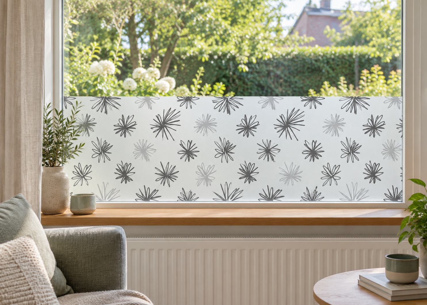 Matglasfolie met speelse bloemen, horizontaal aangebracht boven de vensterbank in een woonkamerraam; ontwerp RFH014B.