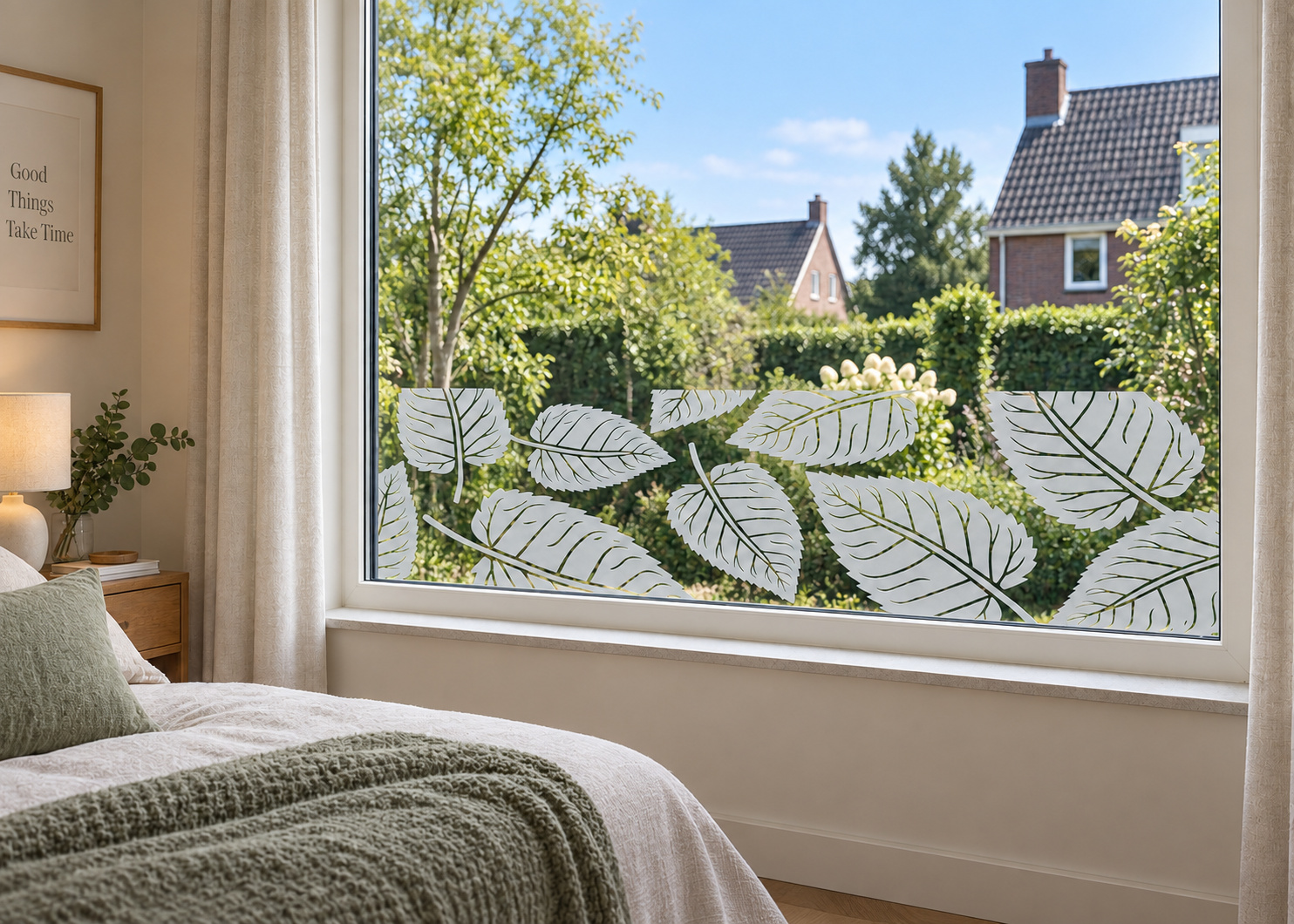 Raamfolie bladpatroon (RFH103) als horizontale raamfolie boven de vensterbank in een slaapkamerraam, met matte folie en doorkijk naar de tuin.