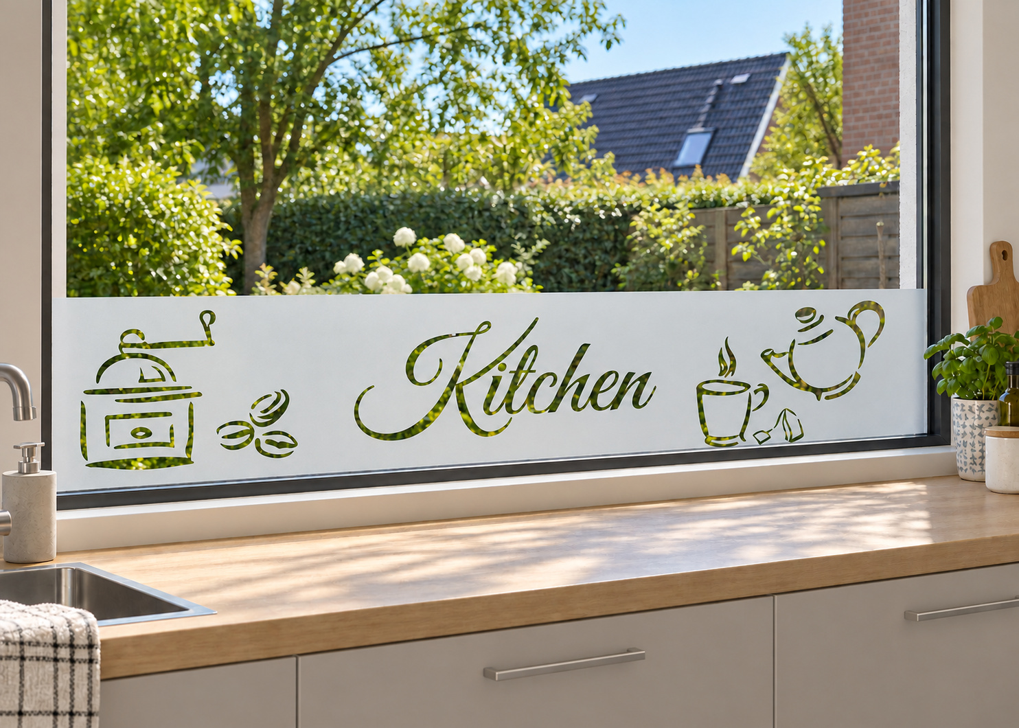 Raamfolie kitchen (RFH071) als horizontale raamfolie boven het aanrecht in een keukenraam, met matte folie en doorkijk naar de tuin.