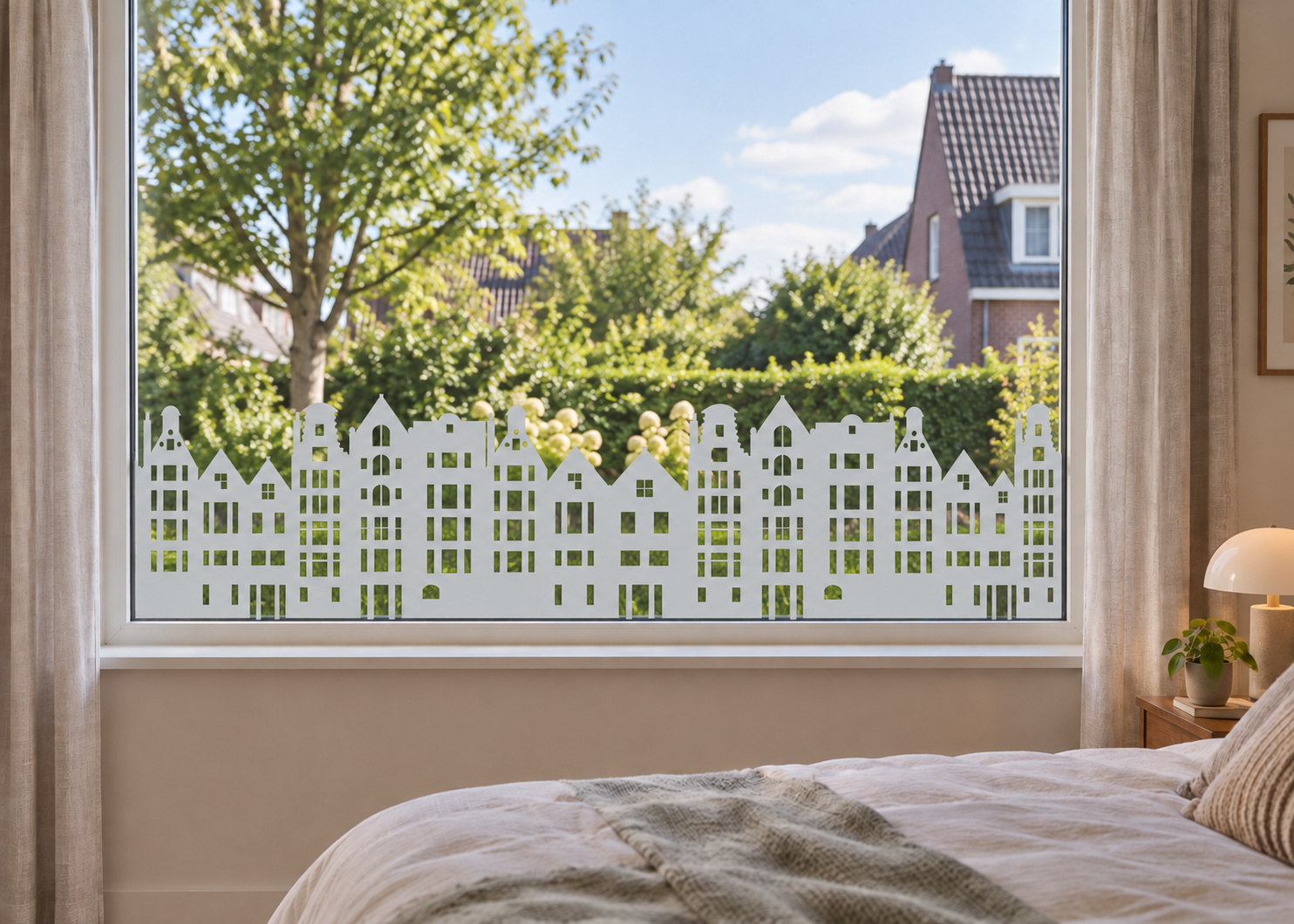 Raamfolie met huisjes (RFH024) als horizontale raamfolie boven de vensterbank in een slaapkamerraam, met matte folie en doorkijk naar de tuin.