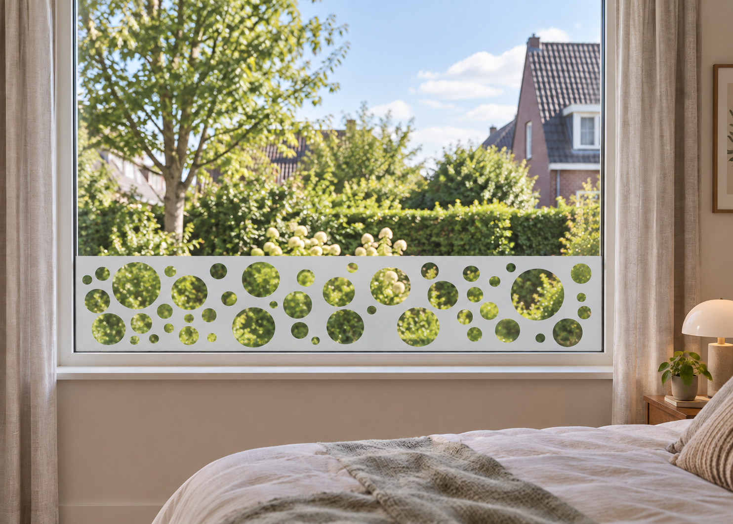 Raamfolie retro cirkels (RFH009) als horizontale raamfolie boven de vensterbank in een slaapkamerraam, met matte folie en doorkijk naar de tuin.