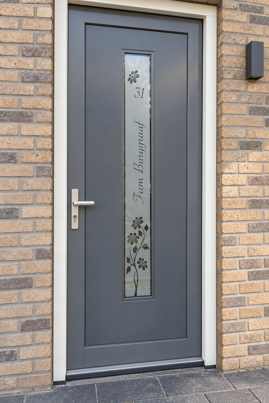 Verticale raamfolie met bloemen en een naam in een smalle, verticale glasstrook in de voordeur.