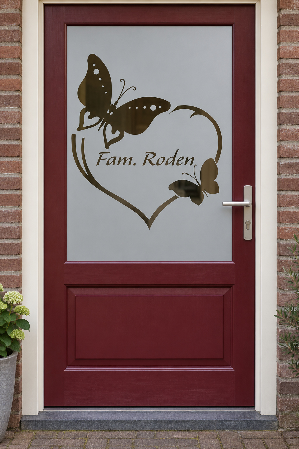 Nederlandse voordeur recht van voren met raamfolie hartje vlinders en naam: een hart met twee vlinders en de familienaam in het midden.