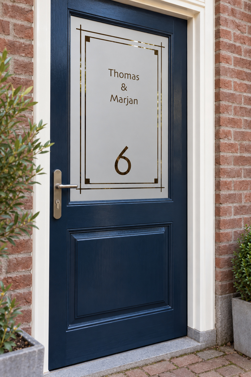 Schuin aanzicht van een Nederlandse voordeur met een dubbel lijnenkader met twee namen en huisnummer in raamfolie strak kader met namen en huisnummer.