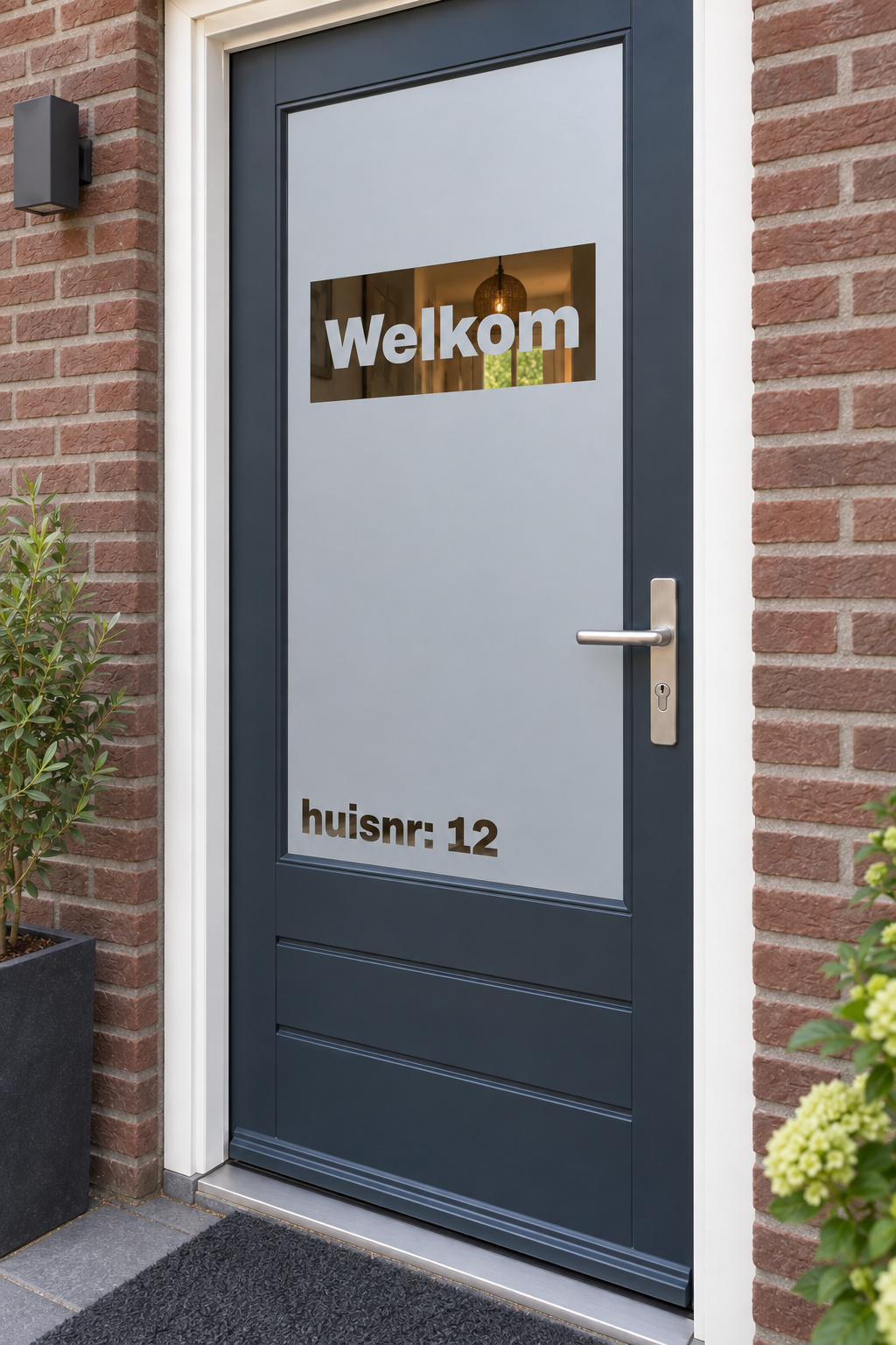 Schuin aanzicht van een Nederlandse voordeur met een uitgesneden rechthoek met Welkom en huisnummer linksonder in raamfolie welkom en huisnummer.